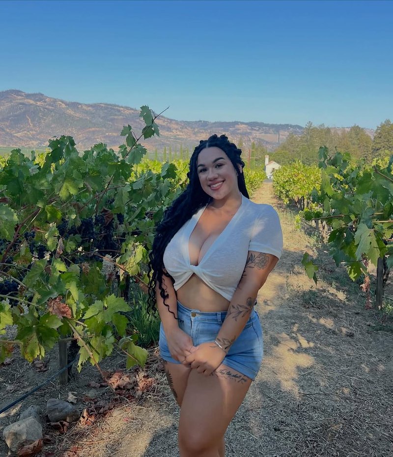 Britt XOXO standing in a vineyard